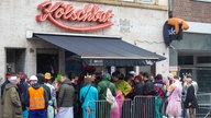 Schlange vor einer vollen Kneipe in Köln am Weiberfastnacht 