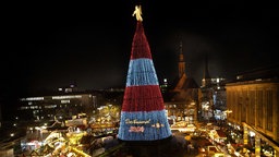 Beleuchtung des riesigen Weihnachtsbaums auf dem Weihnachtsmarkt wird eingeschaltet