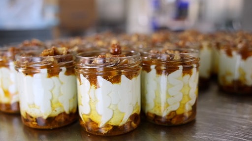 Viele kleine Gläser mit Frischkäse und Datteln.