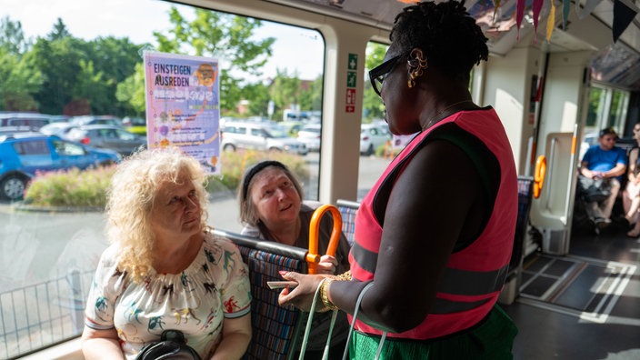 Teilnehmende tauschen sich in einer Stadtbahn aus