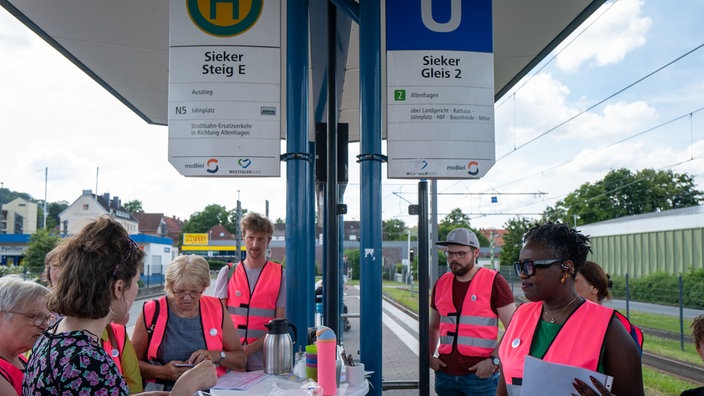 Organisatoren der Begegnungsbahn kommen an einer Haltestelle zusammen