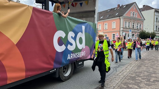 Ein Paradewagen auf dem der Schriftzug "csd Arnsberg" zu lesen ist