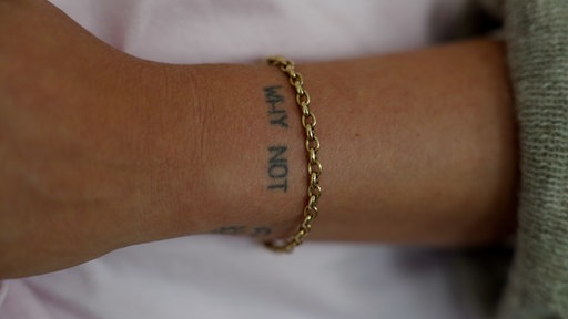 Caros Tattoo am Handgelenk mit der Aufschrift "WHY NOT"