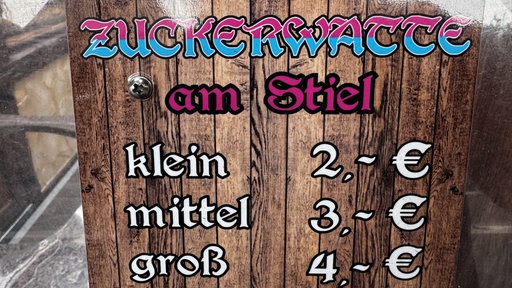 Preise für verschiedene Portionsgrößen von Zuckerwatte am Stiel.
