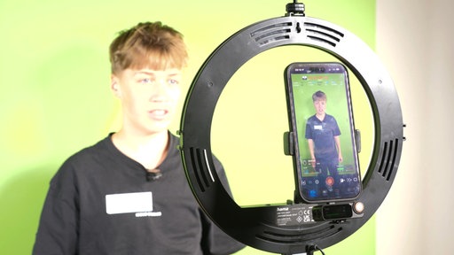 Protagonist steht vor einer Handykammera und nimmt ein Video für ein Social Media News Format auf
