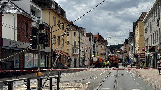 Eine heruntergerissene Oberleitung der Straßenbahn wird von Arbeitern repariert.