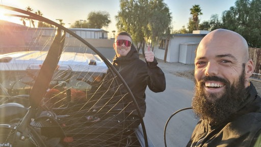 YouTuber Dave und Paramotorpilot Marlon Jonat werden zum Startpunkt gebracht.