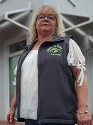 Gabriele Seehusen steht vor einem Gebäude und trägt eine Weste mit der Aufschrift „Hand in Hand“.