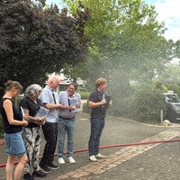 Mehrere Politikerinnen und Politiker werden als Protestaktion nass gespritzt.