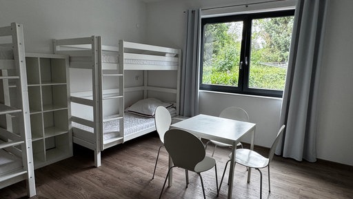 Raum mit Stockbett und einfachem Möbiliar