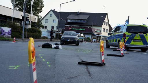 Ein Polizeiauto und ein weiteres Auto stehen an einer abgesperrten Kreuzung.