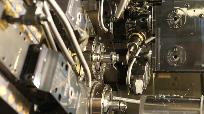 Blick in eine Maschine mit vielen glänzenden Metallteilen