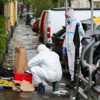 Beamte der Spurensicherung sichern nach einem Messerangriff Beweismittel auf einem Gehweg.