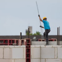Bauarbeiter arbeitet an einem Rohbau für Eigentumswohnungen im Stadtteil Ehrenfeld