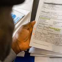 Eine Person mit Migrationshintergrund schaut sich Unterlagen an