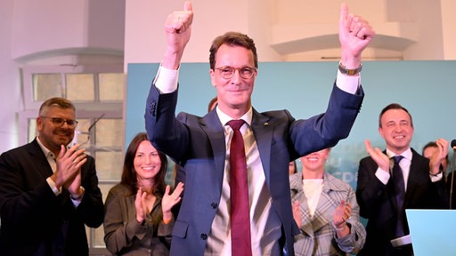 Ministerpräsident Hendrik Wüst ( CDU ) hebt die Arme nach seinem Statement und lässt sich feiern