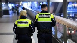 Mitarbeiter der DB Sicherheit gehen durch den Berliner Hauptbahnhof
