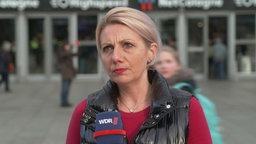 Die Zugbegleiterin Inna Lorenz steht vor dem Kölner Hauptbahnhof