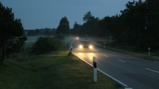 Auf einer Landstraße fahren mehrere Autos durch leichten Nebel
