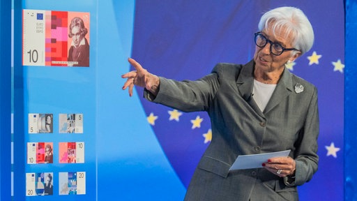 Eine Frau mit grauen Haaren zeigt auf einen Zehn-Euro-Entwurf mit Beethoven-Motiv.