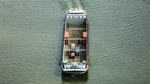 Ein Containerschiff fährt bei Niedrigwasser mit geringer Ladung über den Rhein