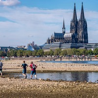 Blick vom rechtsrheinischen Ufer am Rheinpark auf die Innenstadt mit dem Dom und den Rhein bei Niedrigwasser