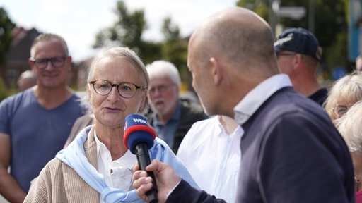 Eine Frau wird von einem Moderator interviewt