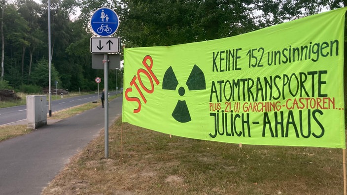 Grünes Protestbanner gegen die Castortransporte von Jülich nach Ahaus am Straßenrand nahe des Forschungszentrums Jülich.