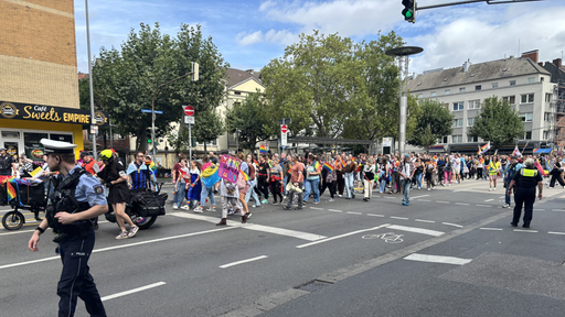 Menschen laufen beim Christopher Street Day von Aachen auf der Straße