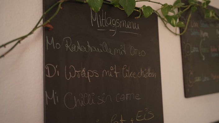 Eine Tafel, auf der der Wochenplan der Wohngruppe steht