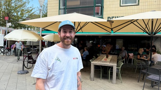 Ein Mann auf dem Markt lächelt in die Kamera
