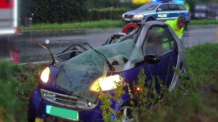 Ein zerstörter Smart steht am Straßenrand. 