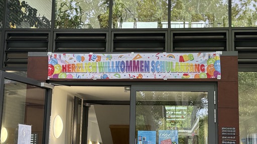 Ein Banner mit "Herzlich Willkommen Schulanfang" ziert den Eingang der KGS Jülich.