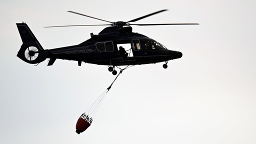 Ein Polizeihubschrauber fliegt über Kleinhau