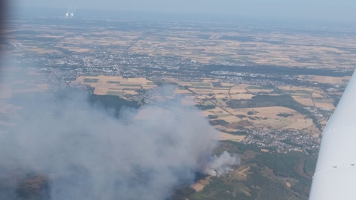 Ein Foto aus dem Flugzeug. Am Boden ist viel Rauch sichtbar.