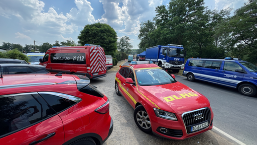 Feuerwehrwagen und Fahrzeuge des Technischen Hilfswerks parken auf einer Straße