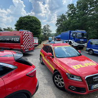 Feuerwehrwagen und Fahrzeuge des Technischen Hilfswerks parken auf einer Straße