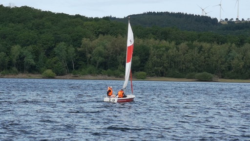 Eine Jolle unter Segeln auf dem Rursee