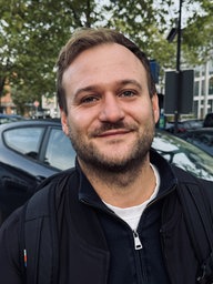 Ein Mann steht auf einem Parkplatz