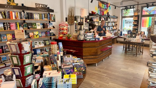Geschäft mit Regalen und Tischen voller Bücher.