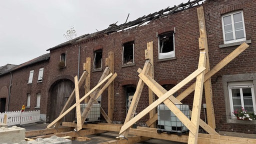 Eine aufwendige Holzkonstruktion ist von außen an eine Häuserwand angebracht. 