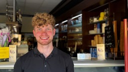 Ein junger Mann steht in einem Eiscafé