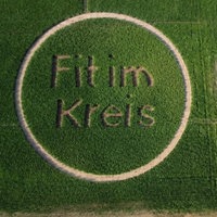 Das Foto zeigt in einer Drohnenaufnahme ein Feld, in das das Motto "Fit im Kreis" dargestellt ist.