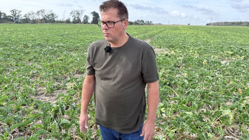Landwirt Christoph Deckers steht in einem grauen T-Shirt auf seinem Acker