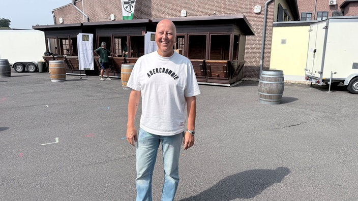 Carsten Forg vom Stadtmarketing Hückelhoven steht vor leeren Verkaufsständen auf dem Weinfest in Hilfahrt 