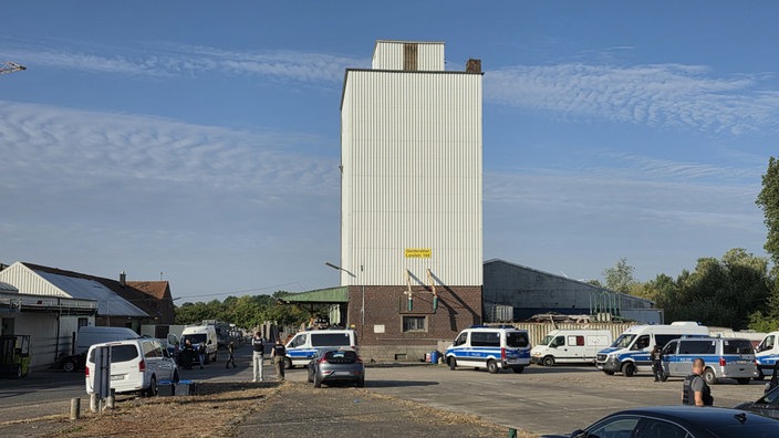 Auf einer Asphaltfläche an der Gerderather Landstraße stehen mehrere Polizeibusse. 