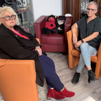 Zwei Psychotherapeutinnen sitzen auf Sesseln in einer Praxis