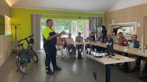 Polizeihauptkommissar Jörg Zimmermann und die Teilnehmenden des Kurses in einem Seminarraum.