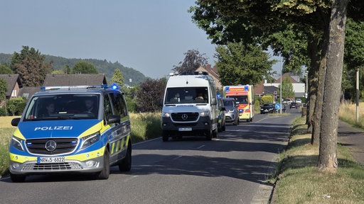 Mehrere Einsatzfahrzeuge fahren die Straße entlang