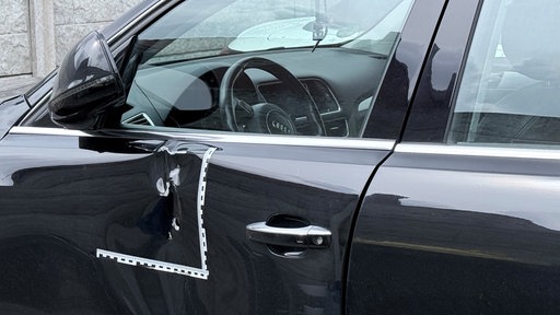 Mehrere Einschusslöcher in einem schwarzen Auto